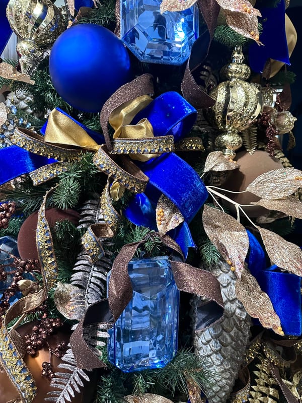 Christmas tree in royal blue, gold, and bronze with ribbon and jeweled ornaments